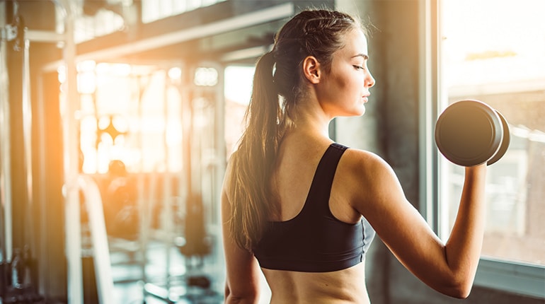 Fitness client flexing arms with coach – resistance training Dubai